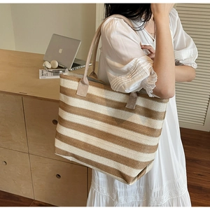 Vue détaillée du grand sac cabas tissé à rayures avec des bandoulières en tissu beige