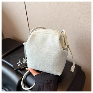 Détail de la texture cuir grainé vert menthe et du support de cadre métallique du sac