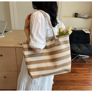 Détail du sac cabas tissé à rayures marron avec des anses claires résistantes