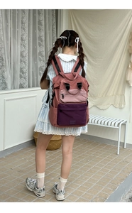 Detail of color-block backpack showing pink and purple corduroy texture and sturdy straps