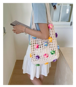 Detailed shoulder view of a cream hand-woven crochet tote bag with 3D colorful flowers