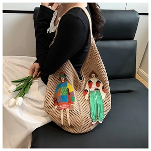 Detail of knit tote bag featuring colorful cartoon embroidery and spacious woven texture