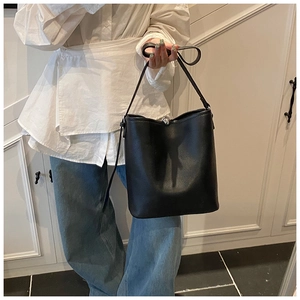 Détail du sac seau noir en cuir avec motif litchi et fermoir magnétique argenté