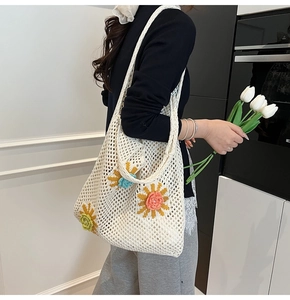 Détail d'un sac cabas au crochet fait main avec motifs floraux 3D colorés et design maille
