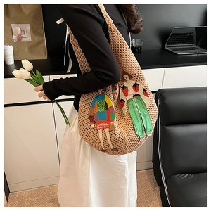 Detail showing the large capacity knitted tote bag with colorful embroidery patches