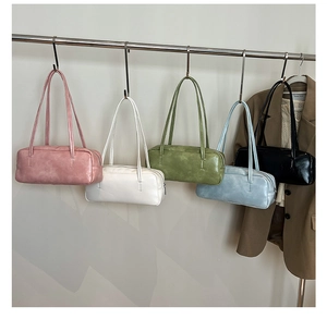 Detailed display of assorted colorful leather baguette bags hanging on minimalist hooks
