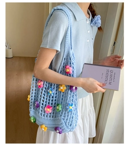 Detail of light blue crochet tote bag with colorful hand-woven floral patterns