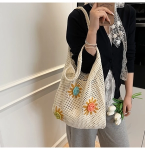 Détail d'un sac à bandoulière en maille crochetée avec des motifs floraux colorés sur tissu