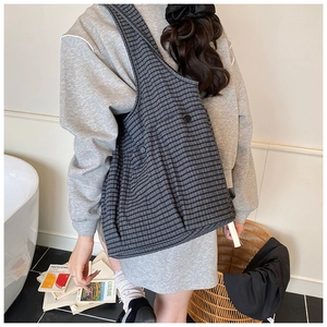 Detail of grey checkered tote bag showing soft fabric texture and casual shoulder carry