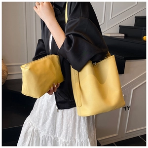 Détail d'un ensemble de sac seau jaune en cuir grainé avec sa pochette zippée assortie