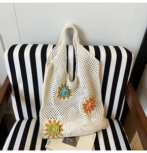 Gros plan du sac fourre-tout au crochet avec trois fleurs 3D colorées de style bohème