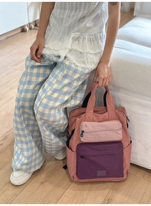 Detail of trendy color-block backpack with multiple zip pockets in lifestyle setting