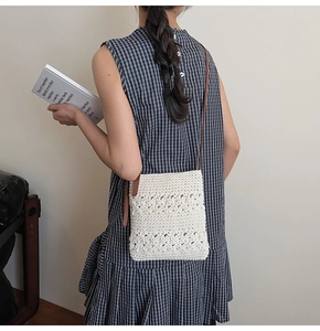 Detailed close-up of a handmade crochet crossbody bag with floral knit patterns