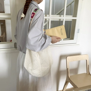 Détail d'un sac cabas au crochet bohème avec bandoulière large aux fleurs tissées