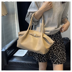 Detail of light beige tote bag with soft leather pleats and slim dual shoulder straps
