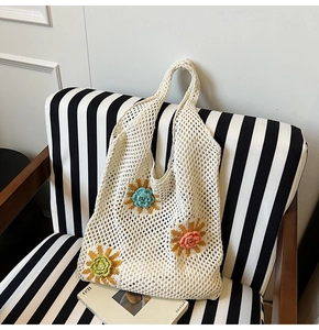 Détail d'un sac cabas au crochet blanc avec fleurs 3D et texture en maille ajourée