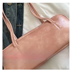 Close-up of pink leather shoulder bag featuring fine grain texture and neat stitching