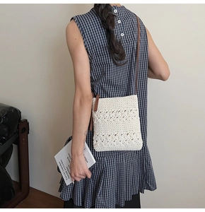 Detail of white crochet square bag with floral patterns and a brown strap