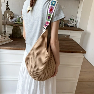 Détail du sac hobo au crochet ajouré avec bandoulière à broderie florale colorée