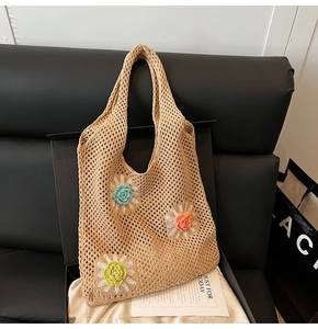 Détail d'un sac cabas au crochet ajouré avec des décorations florales 3D colorées