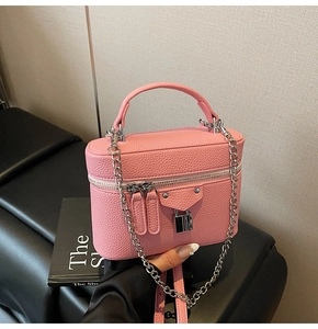 Pink pebbled leather box bag showing silver chain strap and metal lock detail