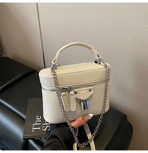 Detailed close-up of a white box-style handbag featuring pebble-textured faux leather