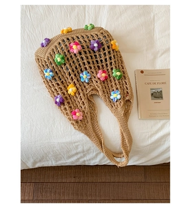 Detailed close-up of 3D crochet flowers and knitted hollow mesh on a beige tote bag