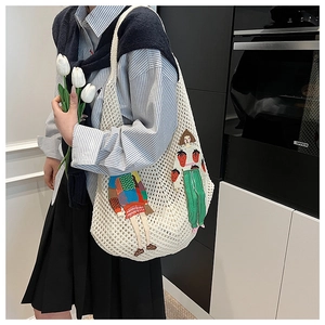 Detail of hand-woven cream crochet tote bag featuring colorful artistic character patches
