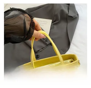 Detail showing the comfortable double handles and smooth zipper of the yellow leather tote