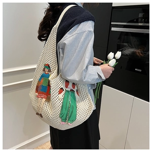 Detail of white crochet shoulder bag with colorful cartoon girl embroidery and knit texture