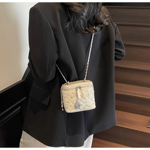 Dettaglio mini borsa bianca trapuntata con cristalli e ciondolo a rosa su catena