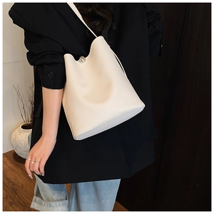 Détail du sac seau blanc en cuir grainé avec fermoir sphérique argenté élégant