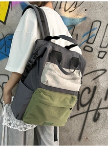 Close-up of color-block nylon backpack with three-tone design and square logo patch