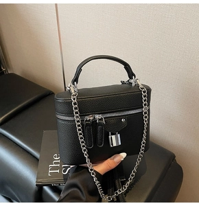 Close-up of black pebble leather handbag with silver padlock detail and chain strap
