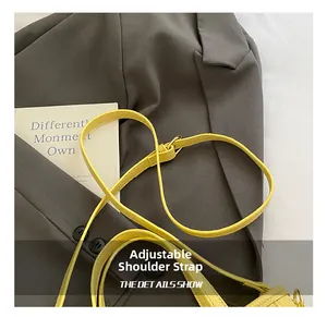 Detail of yellow lychee-textured leather adjustable shoulder strap with metal buckle