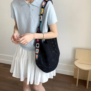 Gros plan d'un sac cabas au crochet noir avec bandoulière brodée de fleurs colorées