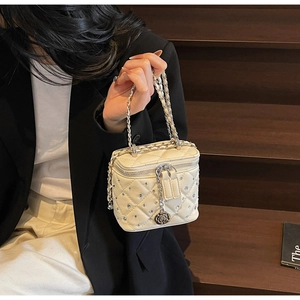 Dettaglio mini borsa bianca trapuntata con strass e ciondolo a forma di rosa in argento