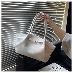 Detail of white leather tote bag with glossy finish and gold metal buckle hardware