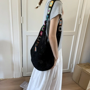 Détail du sac cabas au crochet noir avec bandoulière à fleurs colorées de style rétro bohème