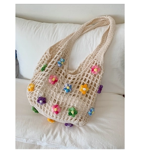 Detailed close-up of handmade crochet tote bag with colorful floral embroidery details