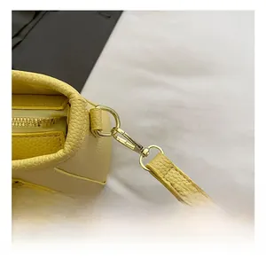Detailed macro view of yellow lychee grain leather texture and golden metal swivel hook