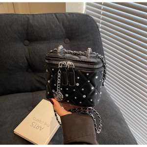Dettaglio mini borsa trapuntata nera con borchie argento e catena ciondolo rosa