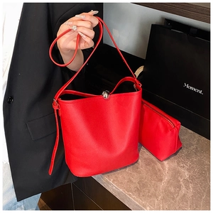 Détail du sac seau rouge en cuir grainé avec fermoir boule argenté et pochette