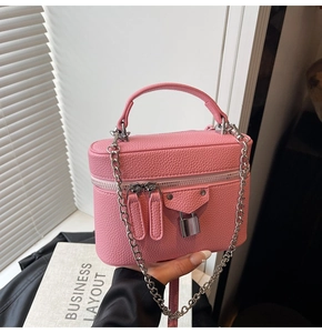 Detailed macro view of pink litchi grain texture and silver metal lock on the box bag