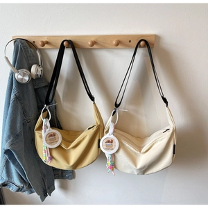 Detail of nylon dumpling bag with capybara charm and adjustable black shoulder strap
