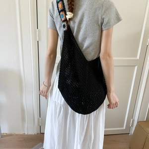 Détail du sac en crochet avec bandoulière à fleurs colorées et motif en maille noire