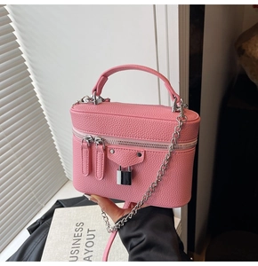 Detailed macro of pink lychee pattern leather box bag with silver metal chain strap