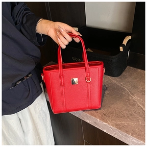 Detailed macro view of red pebbled PU leather texture and gold buckle on bucket bag