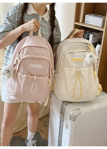 Close-up of pleated nylon backpacks with brand logo and star plush pendants