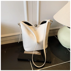 Détail du sac seau en cuir grainé blanc avec fermoir boule en métal argenté élégant